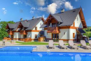 una casa con piscina frente a ella en Czarna Owca, en Jaworki