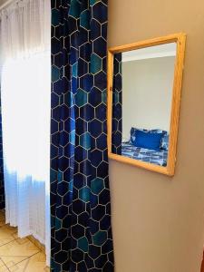 un miroir sur un mur à côté d'une chambre dans l'établissement Izinjiki Namacusi Guest House, à Amsterdam