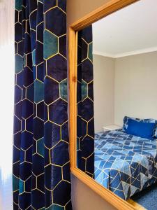 a bedroom with a mirror and a bed at Izinjiki Namacusi Guest House in Amsterdam