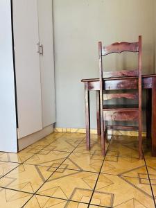 a wooden table and a chair in a room at Izinjiki Namacusi Guest House in Amsterdam