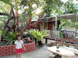 a little girl standing in front of a house at Ennas Place in Coron