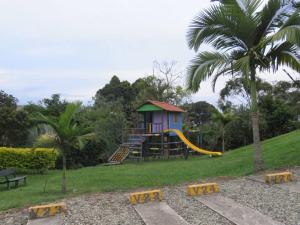 a small playground with a house and a slide at La Tebaida Quindío Reserva de la Colina E104 in La Tebaida