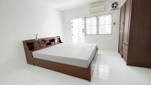 a white bedroom with a bed and a window at Bangkok Private 4Bedrooms-Parking-Weekly Special Offer in Bangkok