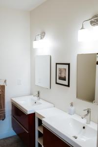 ein Badezimmer mit zwei Waschbecken und zwei Spiegeln in der Unterkunft Pleasant Grove Cottages - Misty Mtn (#113) / Lazy Bear (#115) in Weaverville