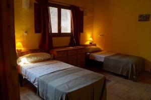 1 dormitorio con 2 camas y ventana. en Mas de l'Aleix- Els Llorers, en Renau
