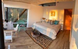 a bedroom with a bed and a large window at Espectacular Loft en Zapallar in Zapallar