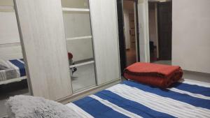 ein Schlafzimmer mit einem Spiegel und einem Bett darin in der Unterkunft Residencia Dos Soles -Resistencia Chaco in Resistencia