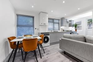 倫敦的住宿－Lovely 2 Bedroom Apartment in Greater London，厨房以及带桌椅的起居室。