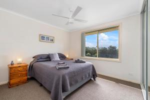 a bedroom with a bed and a window at H1111 Mission Terrace Lakewood Heights Estate in Laurieton