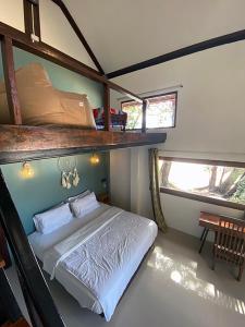a bedroom with a bunk bed in a house at Chomjan Resort in Ko Phayam
