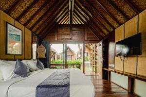 een slaapkamer met een bed en een groot raam bij Bingin Lodge Uluwatu in Uluwatu
