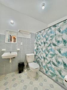 Single Fin Suites & Rooms La punta zicatela في Brisas de Zicatela: حمام مع مرحاض ومغسلة