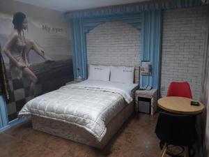 Schlafzimmer mit einem Bett mit Wandgemälde in der Unterkunft Diamond Motel in Sacheon