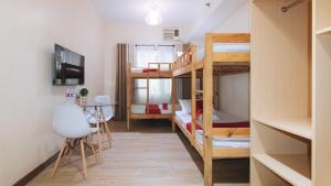 Kleines Zimmer mit Etagenbetten und einem Tisch in der Unterkunft RedDoorz Plus @ Cuarto Verde Staycation in Manila