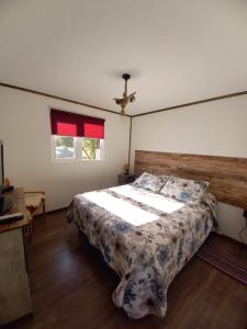 - une chambre avec un grand lit et une tête de lit en bois dans l'établissement Cabañas Altos de Leñadura, à Punta Arenas