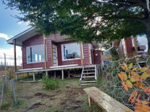 a tiny house with a porch and a tree at Cabañas Altos de Leñadura in Punta Arenas
