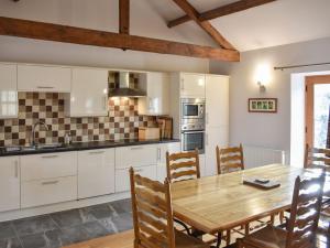 a kitchen and dining room with a wooden table and chairs at Uk39799 - Old Corner Barn in Troutbeck