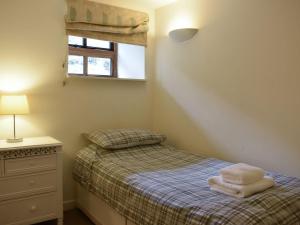 a small bedroom with a bed and a window at Uk39799 - Old Corner Barn in Troutbeck
