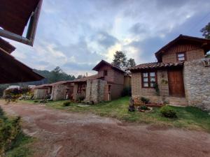 eine Gruppe von Häusern auf einer unbefestigten Straße in der Unterkunft Luchita Mia Eco Cabañas Boutique in Zacatlán