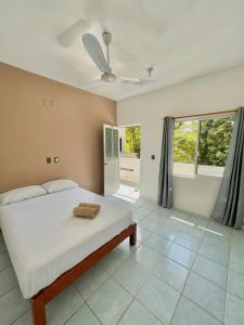 ein Schlafzimmer mit einem weißen Bett und einem Fenster in der Unterkunft Single Fin Suites & Rooms La punta zicatela in Brisas de Zicatela