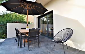 eine Terrasse mit einem Tisch, Stühlen und einem Sonnenschirm in der Unterkunft Gorgeous Home In Montfavet With Outdoor Swimming Pool in Montfavet