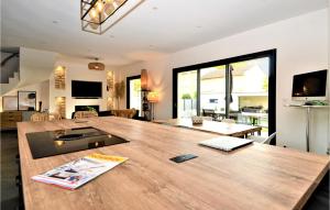 ein großes Wohnzimmer mit einem großen Holztisch in der Unterkunft Gorgeous Home In Montfavet With Outdoor Swimming Pool in Montfavet