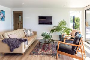 a living room with a couch and two chairs at Moana Retreat in Putaki Bay