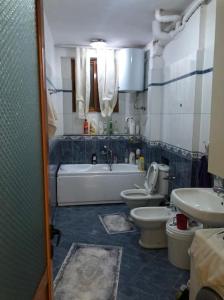 a bathroom with two toilets and a tub and a sink at Luxury appartment Citty center in Fier