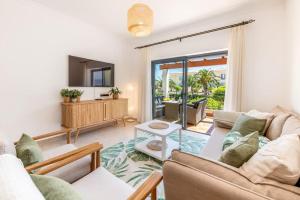 a living room with a couch and a tv at Casa Palmeira in Lagos