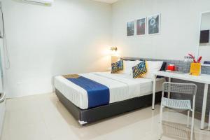 1 dormitorio con 1 cama, 1 mesa y 1 silla en Rumah Teteh Syariah, en Bandung