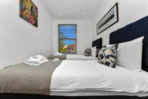 a bedroom with a large bed with white sheets and a window at Amazing 2 Bedroom Apartment in Greater London in London