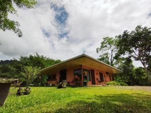 una piccola casa in un campo con un prato di Hospedaje Luis & Ana a Pejibaye