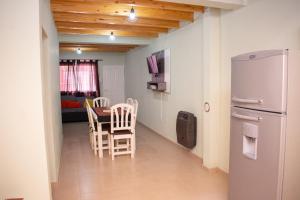 a kitchen with a table and chairs and a refrigerator at Aladdín Departamentos in Ciudad Lujan de Cuyo