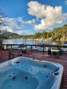 a hot tub on a deck with a view of a lake at Sunshine Coast Resort in Madeira Park