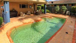 uma piscina no quintal de uma casa em Edward Parry Motel and Apartments em Tamworth