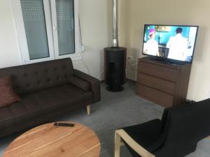 ein Wohnzimmer mit einem Sofa und einem TV in der Unterkunft Georgiadis House in Ammoudia