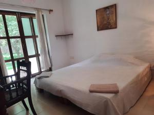 a bedroom with a bed and a picture on the wall at Isai Ambalam guest house in Puducherry