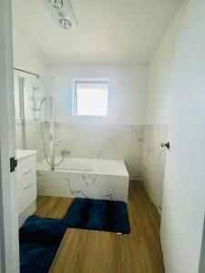 a white bathroom with a tub and a sink at LA SOL 1 - All you need for a stay, close to Uni, town & Cambridge in Hamilton +34 photos