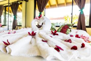 two swans on a bed with roses on them at Fare Manava in Bora Bora