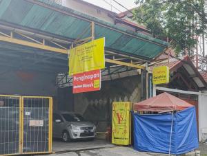 a car parked in front of a building with signs at Yellow Sapphire RedPartner near Mayjend Sungkono in Surabaya +14 photos