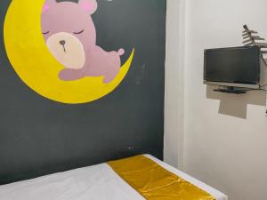 a bedroom with a teddy bear on the moon at Yellow Sapphire RedPartner near Mayjend Sungkono in Surabaya