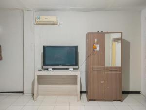 a television sitting on a table next to a cabinet at Yellow Sapphire RedPartner near Mayjend Sungkono in Surabaya