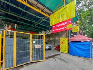 a garage with a gate and a car parked in it at Yellow Sapphire RedPartner near Mayjend Sungkono in Surabaya