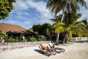 twee mensen zitten in stoelen op het strand bij Fare Manava in Bora Bora