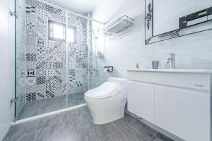 a white bathroom with a toilet and a shower at H& Choco style inn in Taitung City