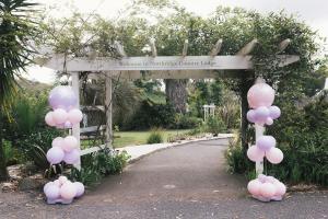 a arch with pink balloons in front of a road at Northridge Golf Resort in Orewa