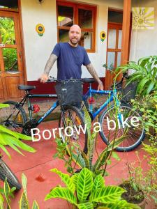 un hombre de pie junto a una bicicleta con una cesta en Hotel Al Sole, en León