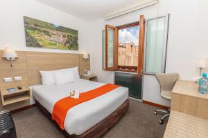 a hotel room with a bed and a desk and a window at Casa Andina Standard Cusco Plaza in Cusco