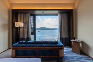 a room with a large window with a view of the water at Hakone Hotel in Hakone