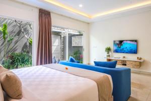 a bedroom with a large bed and blue chairs at Le Cielo Romantic Villas by Maviba in Seminyak